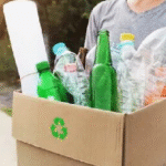 A person holding a recycling box filled with plastic and glass bottles for dry waste collection services in Bangalore by Urban Eco Recyclers
