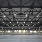 A massive, brightly lit empty exhibition hall in Bangalore after complete event structural dismantling and floor clearing.
